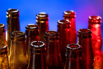 Image showing Neon colored beer bottles. Close up on bright studio background