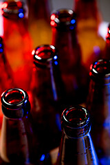 Image showing Neon colored beer bottles. Close up on bright studio background