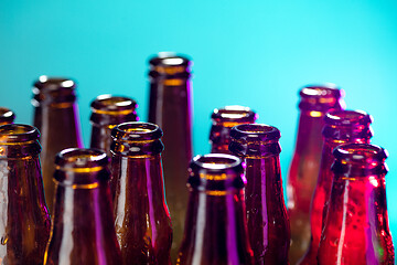 Image showing Neon colored beer bottles. Close up on bright studio background