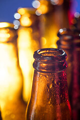 Image showing Neon colored beer bottles. Close up on bright studio background