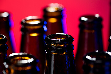 Image showing Neon colored beer bottles. Close up on bright studio background