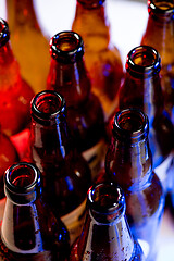 Image showing Neon colored beer bottles. Close up on bright studio background