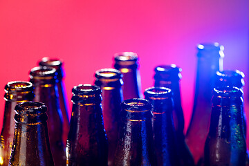 Image showing Neon colored beer bottles. Close up on bright studio background