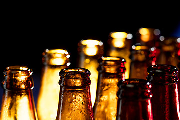 Image showing Neon colored beer bottles. Close up on bright studio background