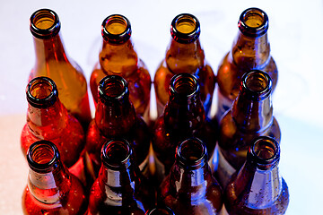 Image showing Neon colored beer bottles. Close up on bright studio background