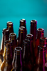 Image showing Neon colored beer bottles. Close up on bright studio background