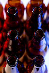 Image showing Neon colored beer bottles. Close up on bright studio background