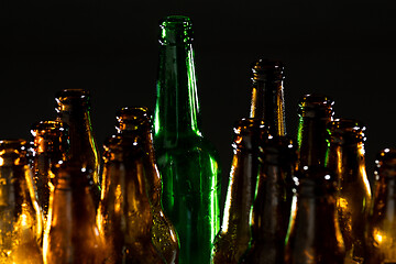 Image showing Neon colored beer bottles. Close up on bright studio background