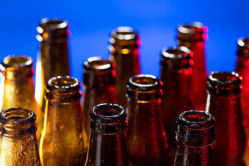 Image showing Neon colored beer bottles. Close up on bright studio background