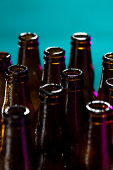 Image showing Neon colored beer bottles. Close up on bright studio background