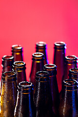 Image showing Neon colored beer bottles. Close up on bright studio background