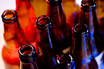 Image showing Neon colored beer bottles. Close up on bright studio background