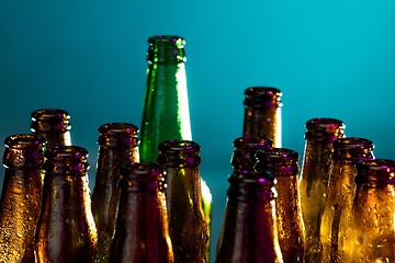 Image showing Neon colored beer bottles. Close up on bright studio background