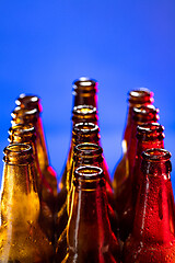 Image showing Neon colored beer bottles. Close up on bright studio background