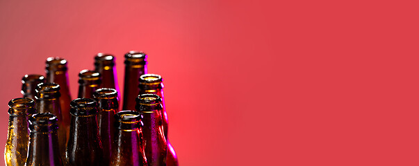 Image showing Neon colored beer bottles. Close up on bright studio background