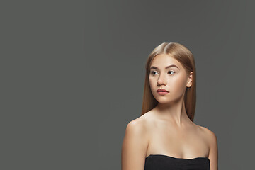 Image showing Beautiful model with long smooth, flying blonde hair isolated on dark studio background.