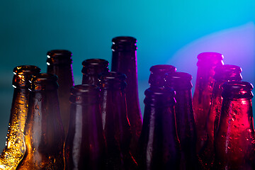 Image showing Neon colored beer bottles. Close up on bright studio background