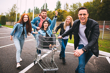 Image showing Group of four young diverse friends in jeanse outfit look carefree, young and happy on city\'s streets