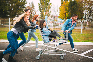 Image showing Group of four young diverse friends in jeanse outfit look carefree, young and happy on city\'s streets