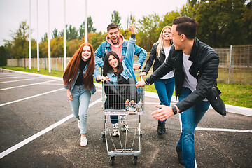 Image showing Group of four young diverse friends in jeanse outfit look carefree, young and happy on city\'s streets