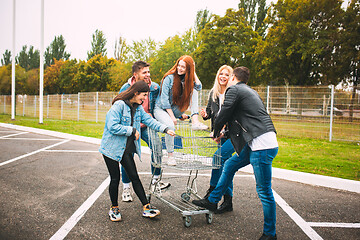 Image showing Group of four young diverse friends in jeanse outfit look carefree, young and happy on city\'s streets