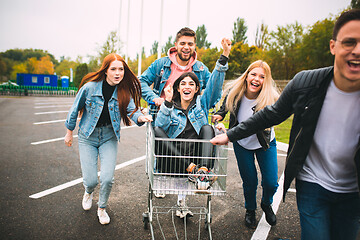 Image showing Group of four young diverse friends in jeanse outfit look carefree, young and happy on city\'s streets