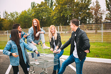 Image showing Group of four young diverse friends in jeanse outfit look carefree, young and happy on city\'s streets