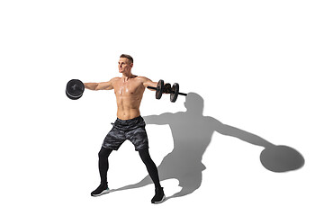 Image showing Beautiful young male athlete practicing on white studio background with shadows