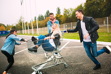 Image showing Group of four young diverse friends in jeanse outfit look carefree, young and happy on city\'s streets