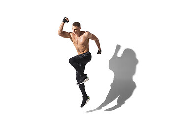 Image showing Beautiful young male athlete practicing on white studio background with shadows