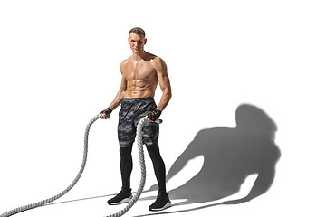 Image showing Beautiful young male athlete practicing on white studio background with shadows