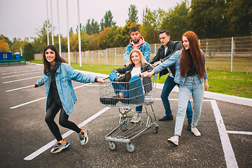 Image showing Group of four young diverse friends in jeanse outfit look carefree, young and happy on city\'s streets