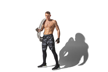 Image showing Beautiful young male athlete practicing on white studio background with shadows