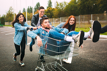 Image showing Group of four young diverse friends in jeanse outfit look carefree, young and happy on city\'s streets