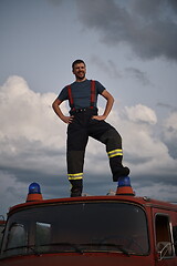 Image showing firefighter out of duty on top of truck