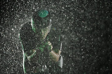 Image showing triathlon athlete riding bike fast on rainy night