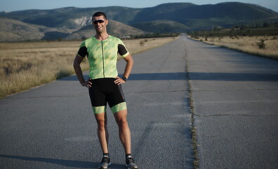 Image showing triathlon athlete resting and setting smartwatch