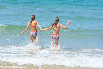 Image showing Girlfriends ran into the sea, view from the back