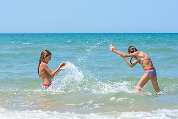 Image showing Girls splash on each other on the sea coast