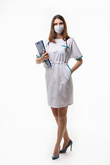 Image showing Girl in medical clothes and mask posing with tablet on white background