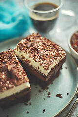 Image showing Delicious chocolate cake with layers served on ceramic blue plate. With cup of fresh black coffe