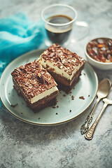 Image showing Delicious chocolate cake with layers served on ceramic blue plate. With cup of fresh black coffe