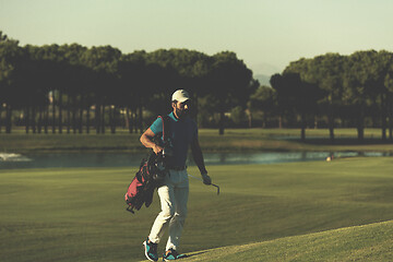 Image showing golfer  walking and carrying bag