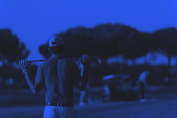 Image showing golfer from back at course looking to hole in distance