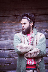 Image showing portrait of young hipster in front of wooden house