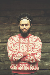 Image showing portrait of young hipster in front of wooden house