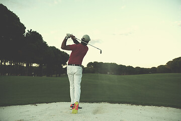 Image showing golfer hitting a sand bunker shot on sunset