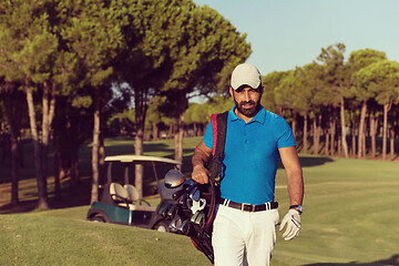 Image showing golfer  walking and carrying golf  bag