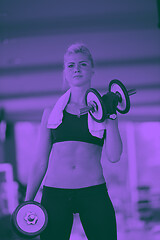 Image showing lifting some weights and working on her biceps in a gym