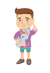 Image showing Caucasian boy crying and holding toy.